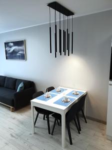 ein Esszimmer mit einem weißen Tisch und schwarzen Stühlen in der Unterkunft ,Private Apartment, Aircondition, Garage, HD TV pl & de, WiFi, fully equipped, near beach in Kołobrzeg