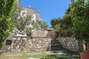 a stone wall and stairs in front of a house at Pandora Studios Skiathos in Skiathos