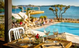 una mesa con copas de vino y vistas a la piscina en Maistra Select Amarin Resort, en Rovinj