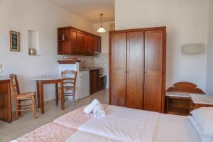 a bedroom with a bed and a kitchen with a table at Pandora Studios Skiathos in Skiathos