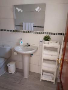 a bathroom with a sink and a toilet and a mirror at La casita de Candida in Tigaday