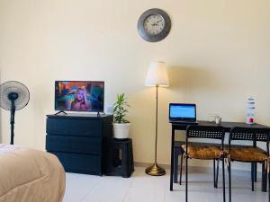 a bedroom with a desk with a laptop and a clock at Wait N Sea !! Sea View Studio Ras Al Khaimah in Ras al Khaimah