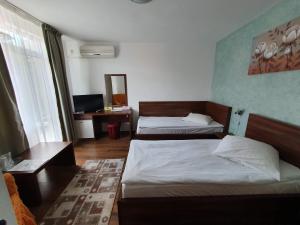 a hotel room with two beds and a desk at Moldotour in Iaşi