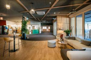 a lobby with couches and tables in a building at JUFA Hotel Weiz in Weiz