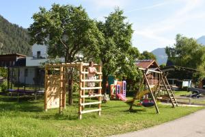 un enfant sur un mur d'escalade dans une aire de jeux dans l'établissement Apart Cäcilia, à Ried im Oberinntal