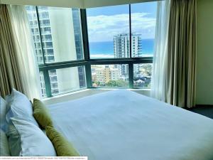 een slaapkamer met een groot bed en een groot raam bij Crown Towers in Gold Coast