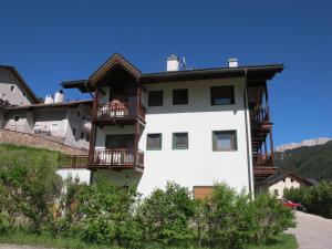 a white building with balconies on a mountain at Villa Ula Verda- Apartments Marianna in Santa Cristina Gherdëina