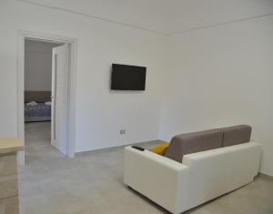 - un salon avec un canapé blanc et une télévision dans l'établissement Al borgo di Cappella, à Monte di Procida