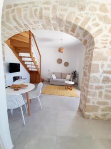 a living room with a table and a stone wall at en lefko in Lefkos Karpathou