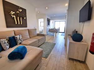 a living room with a couch and a flat screen tv at Apartment Praia Rocha Waterside Blue in Portimão