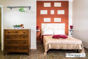 ein Schlafzimmer mit einem Bett und einer Holzkommode in der Unterkunft B&B Kilometrozero in Supersano