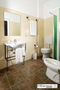 ein Badezimmer mit einem Waschbecken, einem WC und einem Spiegel in der Unterkunft B&B Kilometrozero in Supersano