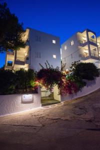 a white building with flowers in front of it at Christine Studios in Poros