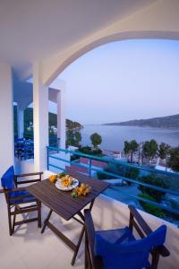 a table on a balcony with a view of the water at Christine Studios in Poros