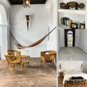 Habitación con mesa, sillas y hamaca. en Casa Bablou, en Sanlúcar de Barrameda