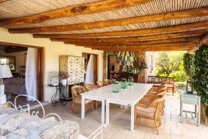 un patio esterno con tavolo e sedie bianchi di Albero Capovolto a Golfo Aranci