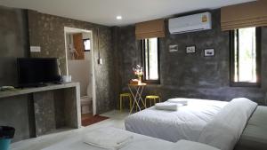 a hotel room with two beds and a television at บ้านแก่งรีสอร์ท เชียงคาน in Chiang Khan