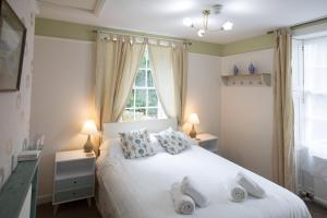 a bedroom with a white bed with two towels on it at Rydal Lodge in Rydal