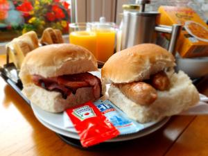 two sandwiches on a plate with waffles and orange juice at Knap Guest House in Tarbert