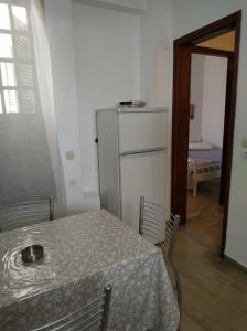 a kitchen with a table and a white refrigerator at Nancy's Rooms in Gouvia