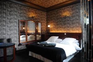 ein Schlafzimmer mit einem großen Bett und einem Spiegel in der Unterkunft Le Berger Hotel in Brüssel