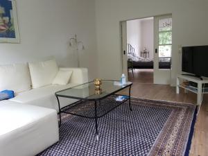 ein Wohnzimmer mit einem weißen Sofa und einem Glastisch in der Unterkunft Ganze Wohnung mit Garten in Bremen