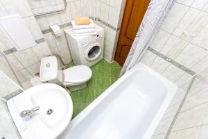 a bathroom with a toilet and a sink and a tub at Studiominsk 6 Apartments in Minsk