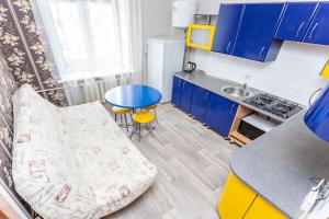 a small kitchen with blue cabinets and a blue table at Studiominsk 6 Apartments in Minsk