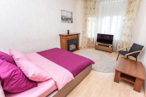 a bedroom with a bed and a fireplace and a television at Studiominsk 6 Apartments in Minsk