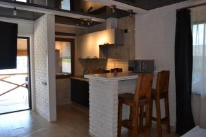 a kitchen with a counter and chairs in a room at Pryvatna Sadyba Tviy Kut in Svityazʼ