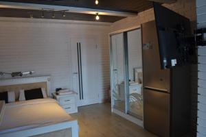 um pequeno quarto com uma cama e um frigorífico em Pryvatna Sadyba Tviy Kut em Svityazʼ