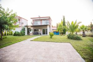 a house with a pathway in front of it at Sani villa perfect for family vacations in Sani Beach