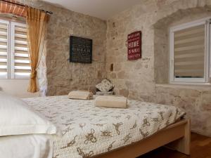 Villa Nautica Stone House في سبليت: غرفة نوم بسرير في جدار حجري