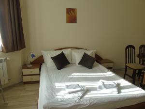 a bedroom with a white bed with two utensils on it at Хотел Флора private studio All seasons in Borovets