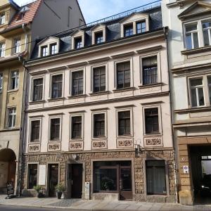 ein großes weißes Gebäude mit Fenstern auf einer Straße in der Unterkunft City-Ferienwohnungen-Dresden - zentral gelegen im Haus Louisenstrasse 11 - Dresden-Neustadt in Dresden