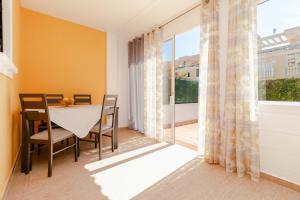 een eetkamer met een tafel en stoelen en een groot raam bij Espanatour AGUAMARINA in Torrevieja