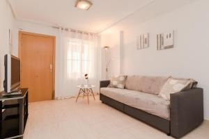 een woonkamer met een bank en een televisie bij Espanatour AGUAMARINA in Torrevieja