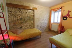 a bedroom with two beds and a brick wall at le domaine de bellevue in Tanzac +42 photos