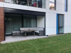 a patio with couches and a table in front of a building at Port Apartman Siófok in Siófok