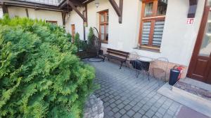 a patio with a bench and a bush in front of a house at Apartamenty Patria in Krakow