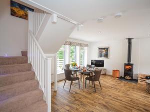 a living room with a table and chairs and a fireplace at Squirrel Cottage in Stranraer