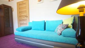 Apartamenty Patria في كراكوف: أريكة زرقاء في غرفة المعيشة مع مصباح