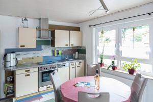 a kitchen with a table and a kitchen with white cabinets at Ferienwohnung Münch mit Balkon in Großheubach