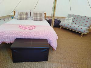 a bedroom with a bed and a couch in a tent at Yr Wyddfa Bell Tent - Pen Cefn Farm, Abergele, Conwy in Abergele