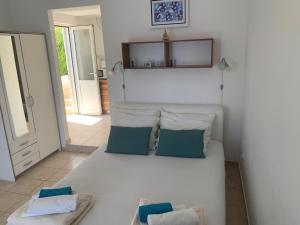 a room with a white bed with two pillows at Studio Apartments More in Korčula