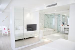 a white room with a large mirror and a television in it at Boscolo Nice Hotel & Spa in Nice