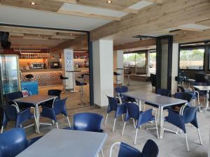 a dining room with tables and blue chairs at Hotel Internacional in Calella