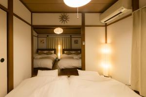 東京にあるYoshinaga heightsのベッド2台と鏡のある寝室