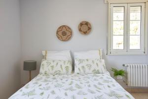 um quarto com uma cama com um edredão verde e branco em Enoturismo Casa de Chantada em Meis