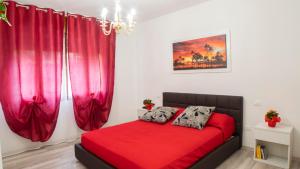 1 cama roja en una habitación con cortinas rojas en B&B La Valle Verde, en Miane